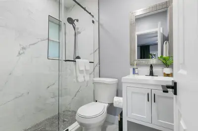a white bathroom with a toilet and a shower at Modern Miami Oasis with Pool & Water View in North Miami