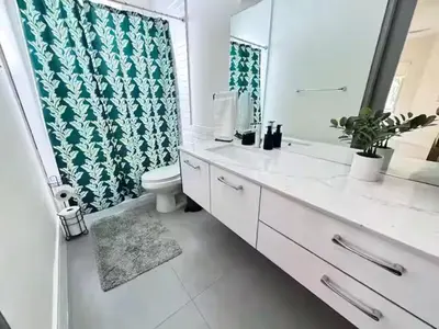 a bathroom with a sink and a toilet and a mirror at Lux Villa Sol in Miami