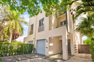a house with palm trees in front of it at Lux Villa Sol in Miami