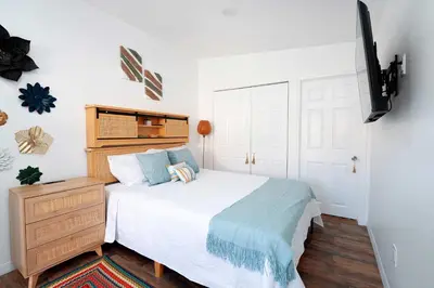a bedroom with a white bed and a dresser and a bed sidx sidx sidx at Rio retreat - Unit B in Miami