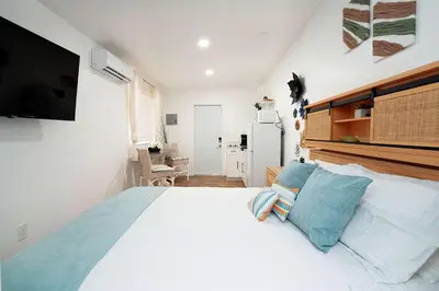 a bedroom with a large bed with a television on the wall at Rio retreat - Unit B in Miami