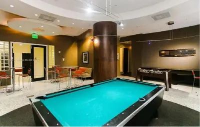 a pool table in a living room with a billiardenge at Oceanview 3BR Penthouse | Pool + Beach Access in Hallandale Beach