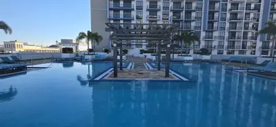 a swimming pool with blue water in front of a building at Modern Studio in Downtown Doral in Miami