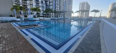 a large swimming pool with blue water in a building at Modern Studio in Downtown Doral in Miami