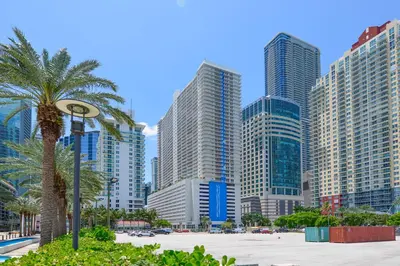 a city skyline with tall buildings and a palm tree at Luxury Suite | Sauna, Pool & Resort Access in Miami