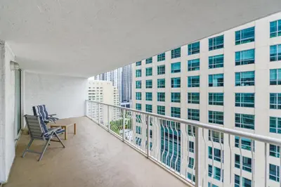 a balcony with chairs and a view of a building at Luxury Bayview Condo | Pool, Gym & Skyline Views in Miami