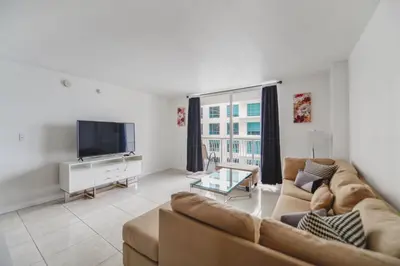 a living room with a couch and a tv at Luxe 2BD Unit | W Sauna, Pool & Gym access in Miami