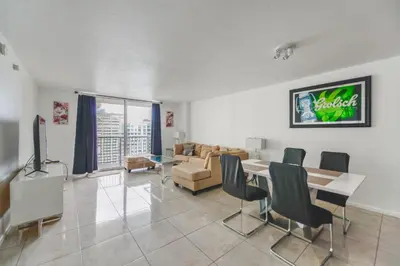 a living room with a table and chairs and a couch at Luxe 2BD Unit | W Sauna, Pool & Gym access in Miami