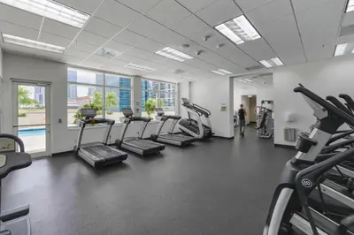 a gym with treadmills and elliptical machines at Luxury 2BD Condo | Sauna, Pool & Resort Access in Miami
