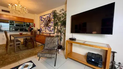 a living room with a television and a dining room at Urban Warmth Retreat in Miami
