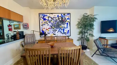 a dining room with a table and a painting on the wall at Urban Warmth Retreat in Miami