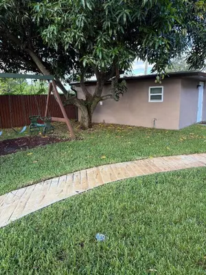 a swing set in a yard next to a tree at Peace and Tranquility awaits in Miami Gardens