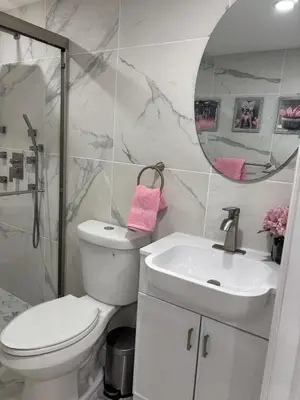 a bathroom with a toilet and a sink and a mirror at Peace and Tranquility awaits in Miami Gardens