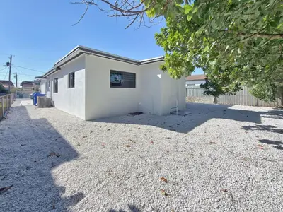 a white building sitting on top of a gravel driveway at Miami Lux Retreat - Free Parking - Near Brickell in Miami