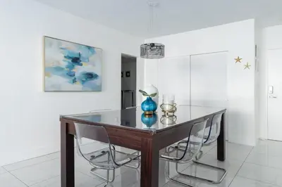 a dining room with a glass table and chairs at Hollywood 1 BR Apt w Gym and Pool near the Beach in Hollywood