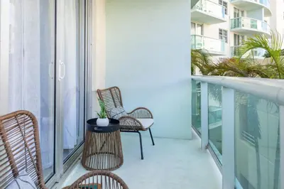 a balcony with chairs and a table with a plant on it at Hollywood 1 BR Apt w Gym and Pool near the Beach in Hollywood