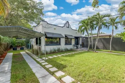 a white house with a yard with palm trees at Casa Palma in Miami