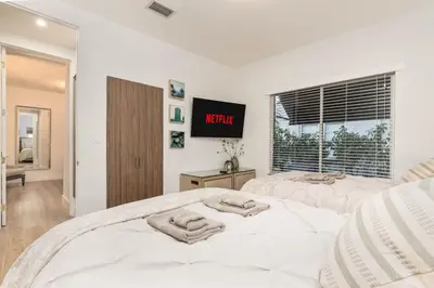 a bedroom with two beds and a tv on the wall at Casa Palma in Miami