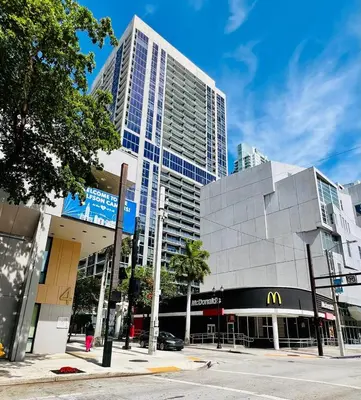 a tall building with a mcdonalds restaurant on a city street at Live Miami Vibes 2 Bedrooms Bayside Steps City Views Pool in Miami