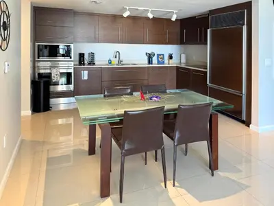 a kitchen with a glass table and chairs in it at Modern 1B at Icon Brickell 32nd fl Pool Spa Gym FREE Parking Scenic view in Miami