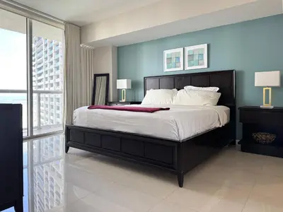 a bedroom with a large bed with a blue wall at Modern 1B at Icon Brickell 32nd fl Pool Spa Gym FREE Parking Scenic view in Miami