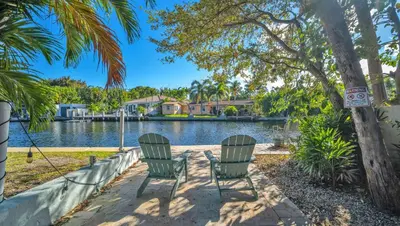 two chairs in front of a lake with houses at Later Gator - Pool - Canal - Wilton Drive in Fort Lauderdale