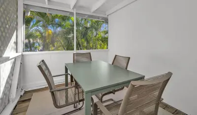 a table and chairs in a room with a window at Later Gator - Pool - Canal - Wilton Drive in Fort Lauderdale
