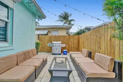 a patio with a couch and a table and a fence at Cozy three bedroom near Hollywood beach in Hollywood