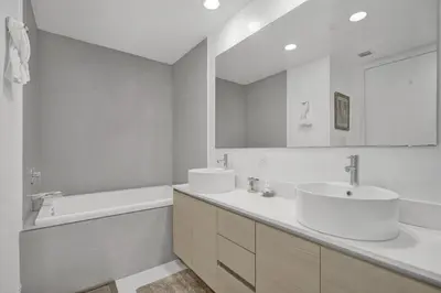 a bathroom with two sinks and a tub and a mirror at Ocean View 3 BDR Condo Pool Gym Private Balcony in Hallandale Beach