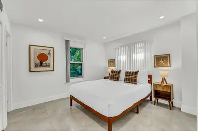 a white bedroom with a bed and a window at Bright 1BR Getaway Victoria Park Las Olas Nearby in Fort Lauderdale