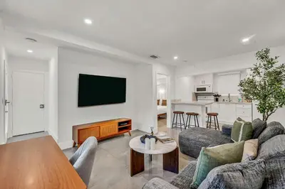 a living room with a couch and a tv on a wall at Bright 1BR Getaway Victoria Park Las Olas Nearby in Fort Lauderdale