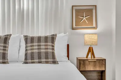 a bedroom with a bed and a table with a lamp at Bright 1BR Getaway Victoria Park Las Olas Nearby in Fort Lauderdale