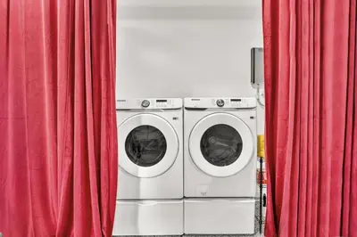 two washing machines in a room with red curtains at Lux Villa Heated Pool, Gym, Games, Golf, Near Beach in Hollywood