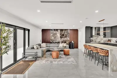 a living room with a couch and a kitchen at Lux Villa Heated Pool, Gym, Games, Golf, Near Beach in Hollywood