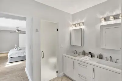 a white bathroom with a sink and a mirror at Oasis 5 Bed, 3 Bath Pool Home Minutes to the Beach in Hollywood