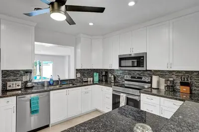 a kitchen with white cabinets and a ceiling fan at Stylish 4 Bed 2 Bath Pool & Spa in Hollywood