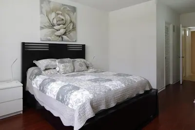 a bed in a bedroom with a painting on the wall at Beautiful Sunny Isles apt 1br with PRIVATE TERRACE in Sunny Isles Beach
