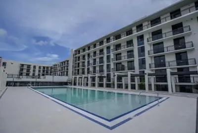 a large building with a swimming pool in front of it at Sleep 6 in Resort Style Community- Near Stadium in North Miami