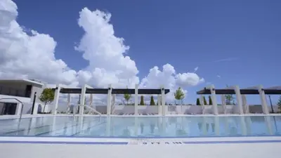 a building with a swimming pool in front of it at Sleep 6 in Resort Style Community- Near Stadium in North Miami