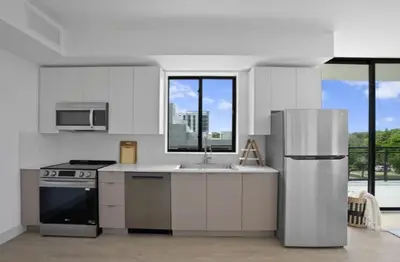 a kitchen with a stainless steel refrigerator and a sink at Sleep 6 in Resort Style Community- Near Stadium in North Miami