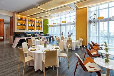 a restaurant with white tables and chairs and windows at The Grayson Hotel Miami Downtown in Miami