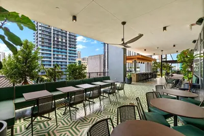 a restaurant with tables and chairs on a balcony at Fly Hight - Studio W Free Parking in Miami