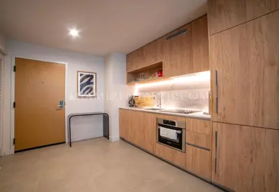 a kitchen with wooden cabinets and a sink at Crosby Miami World Center in Miami