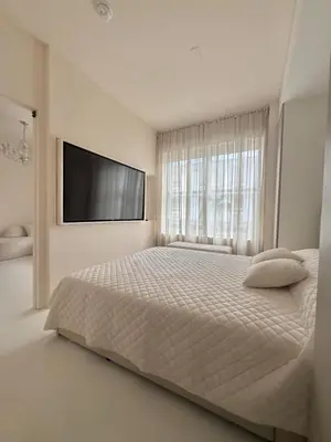 a white bedroom with a large bed and a flat screen tv at Chic & Cozy 1BR in Miami Best South Beach Location in Miami Beach