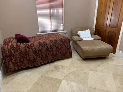 a bedroom with a bed and a chair at Miami Mansion for Groups Sleeps 12 in Kendale Lakes