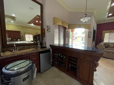a kitchen with a counter with a sink and a mirror at Miami Mansion for Groups Sleeps 12 in Kendale Lakes