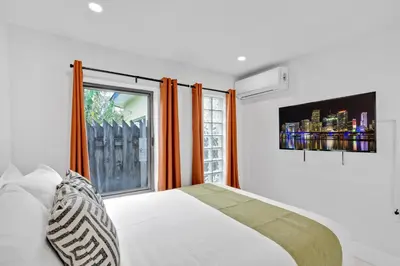 a bedroom with a white bed and a window at Waterfront Pool Home Games, 10 min to Beach in Fort Lauderdale