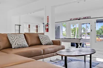 a living room with a couch and a table at Waterfront Pool Home Games, 10 min to Beach in Fort Lauderdale