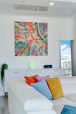 a living room with a white couch with colorful pillows at Vibrant Downtown Haven with Rooftop Pool & Parking in Miami