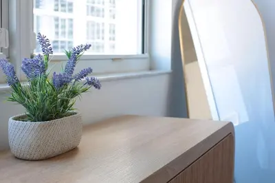 a vase with purple flowers sitting on a table at Modern Luxury Studio for Two in Downtown in Miami
